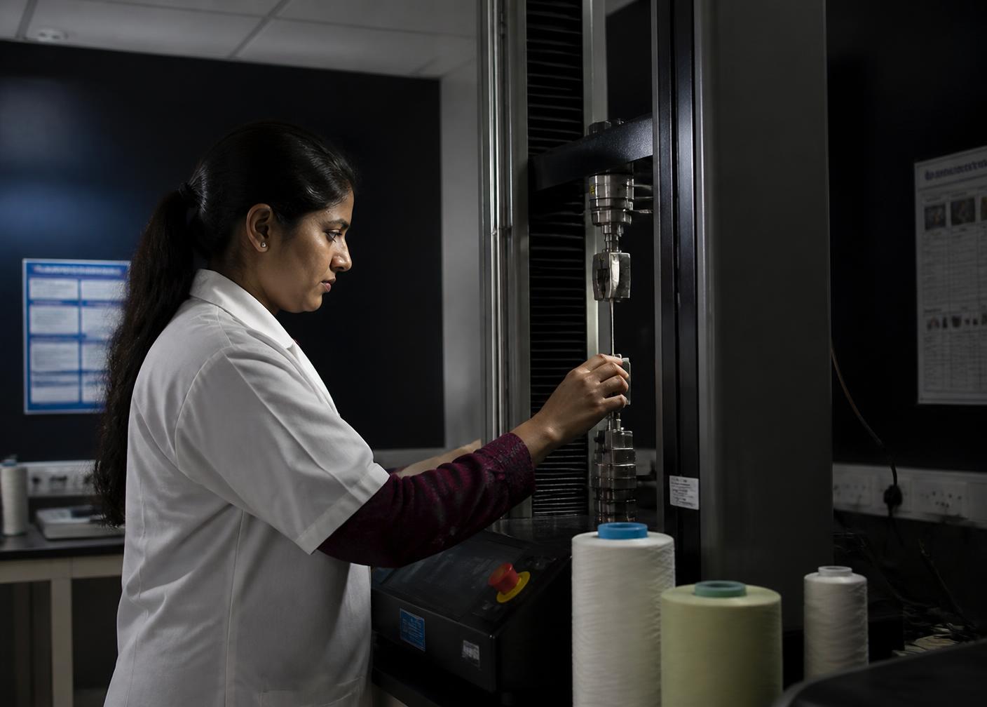 Laboratory technician performing yarn strength testing